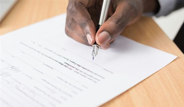 Man writing report with pen